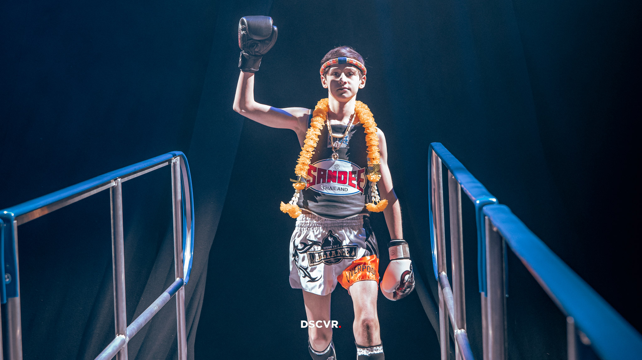 a muay thai fighter walking out, blue blackground